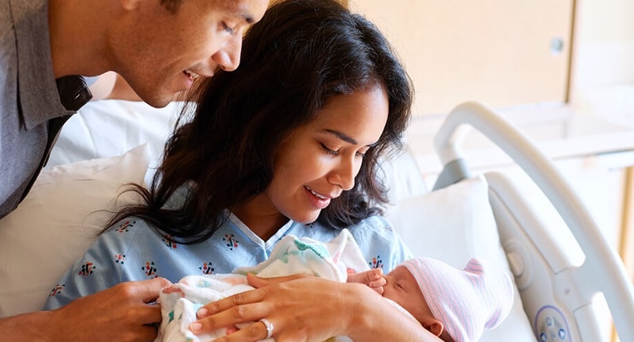 Couple smiling at newborn