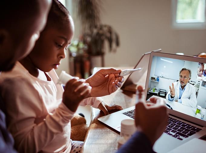 child with parent receiving healthcare digitally