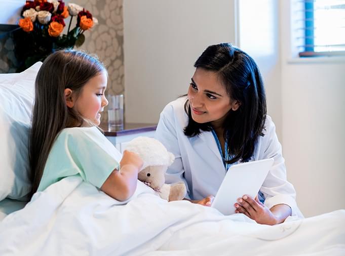 doctor holding device while caring for child patient