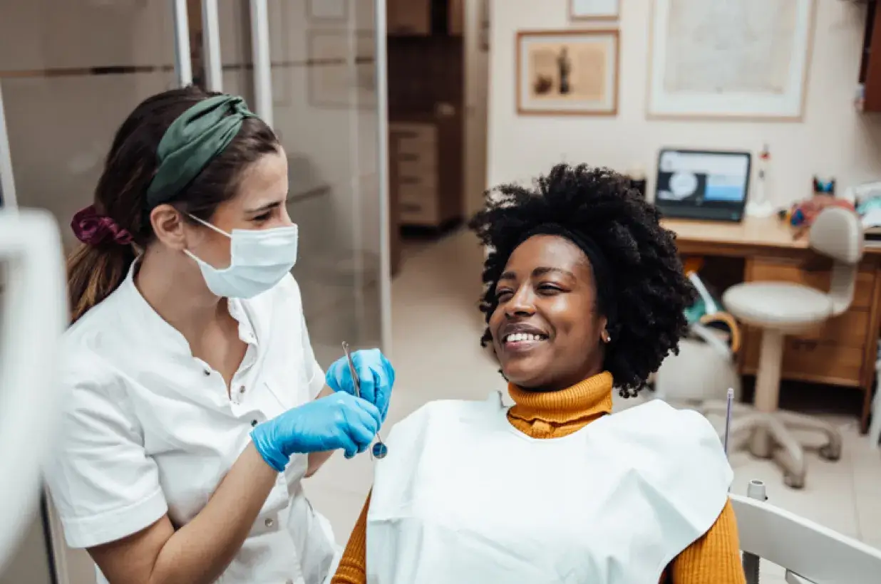 female dental assistant chatting with a smiling patient