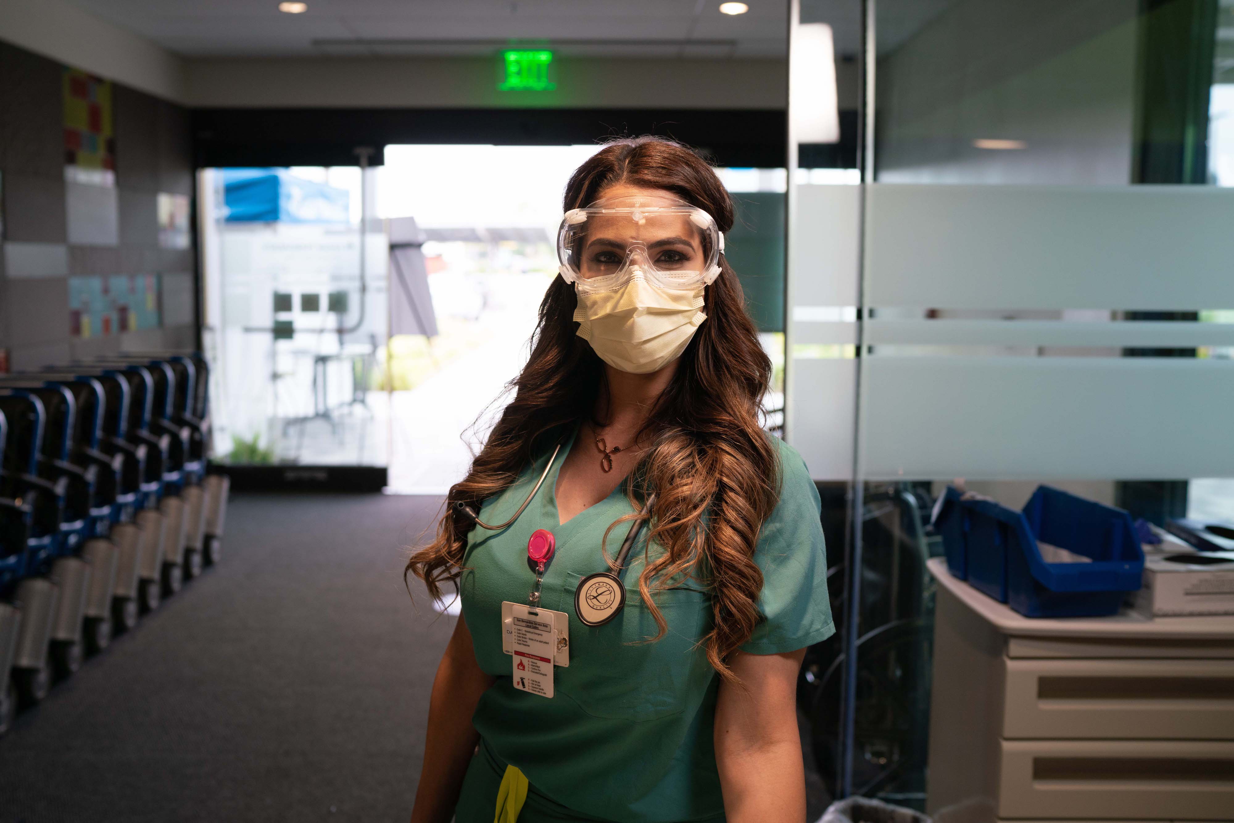 young woman with long hair wearing ppe mask