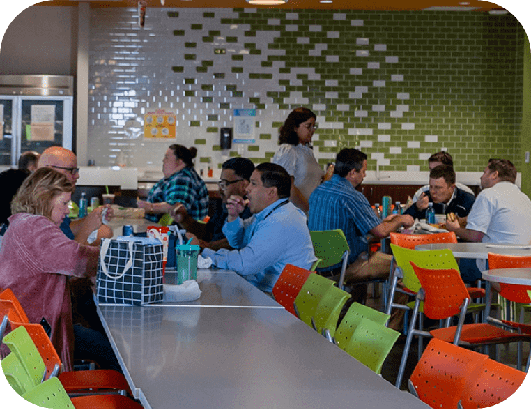  colleagues sitting and eating together in a dining hall