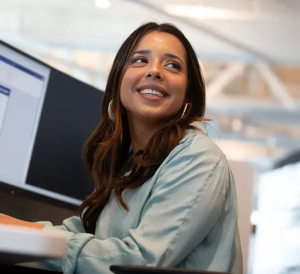 Woman smiling at a desktop computer