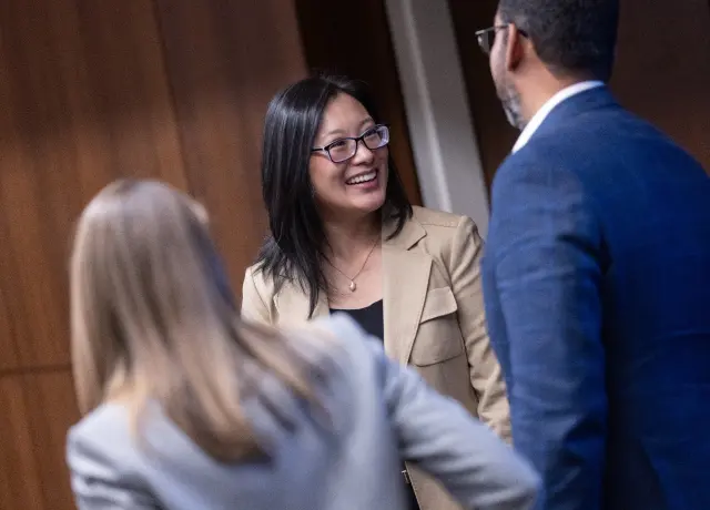 Lady smiling while talking to two people
