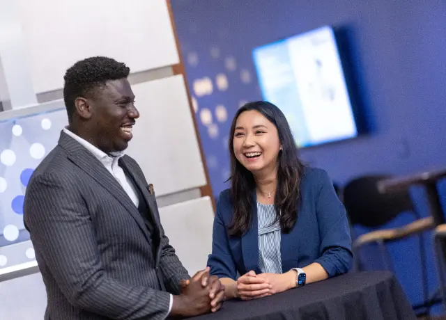 Woman and man smiling in a conversation at a table