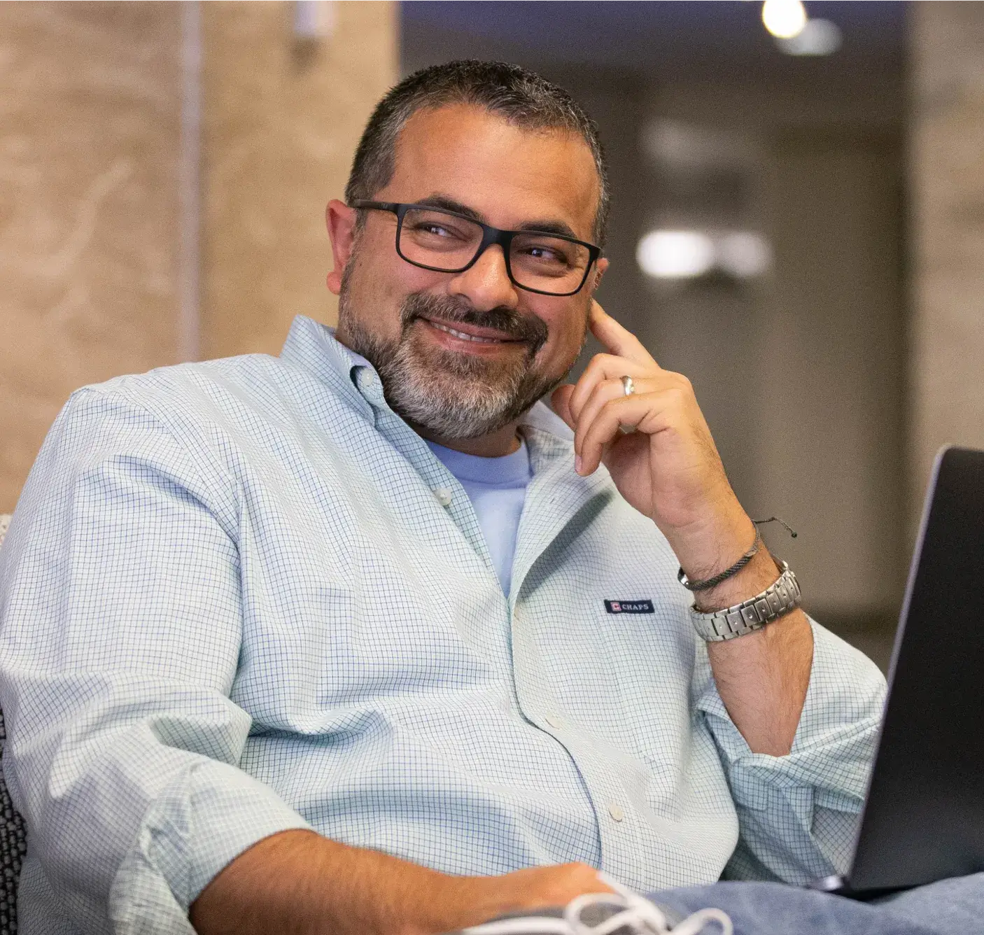Employee smiling in front of a laptop