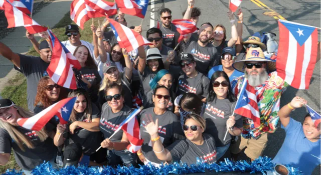 large group of people smiling and waving flags