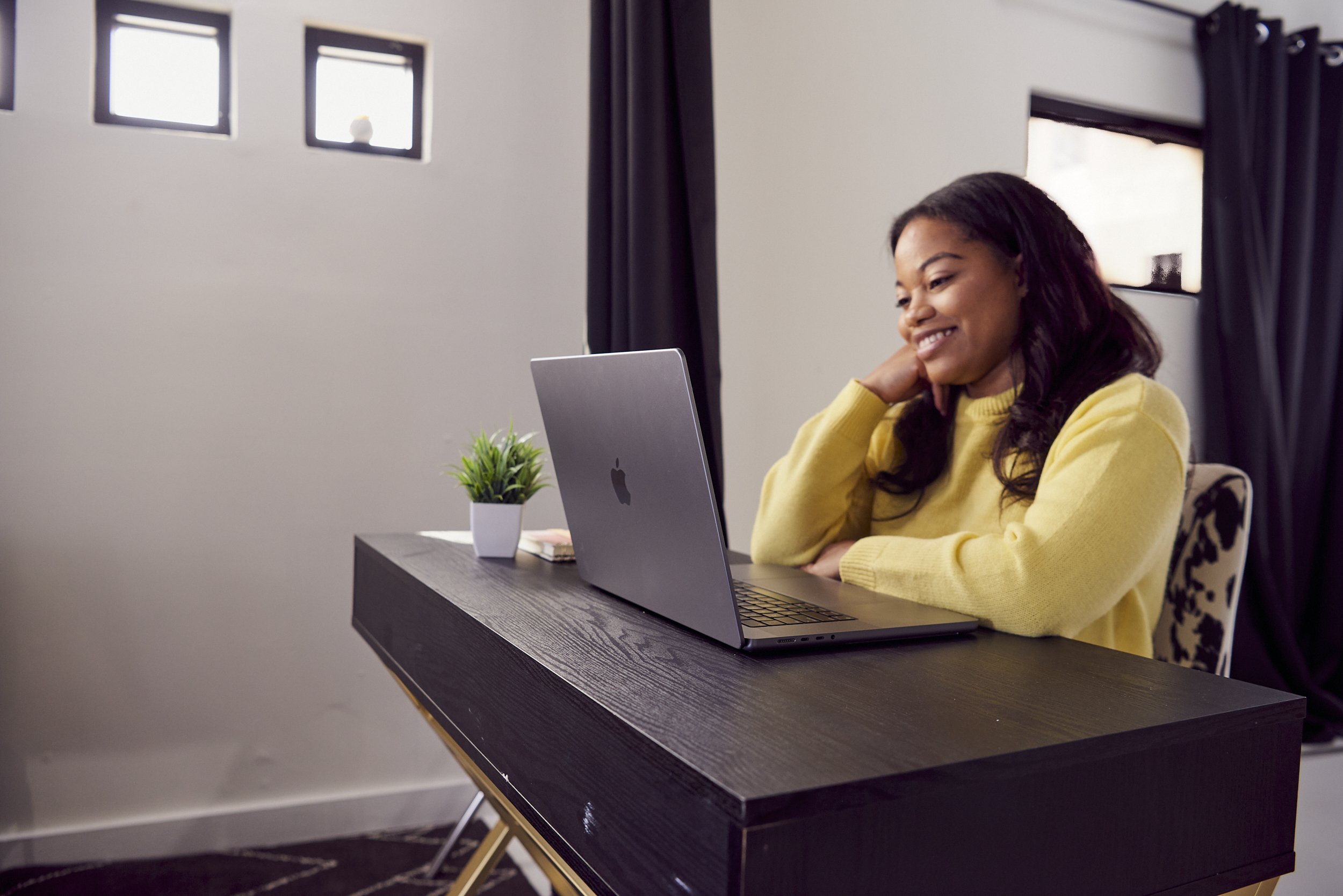 person on a virtual interview, smiling at a computer