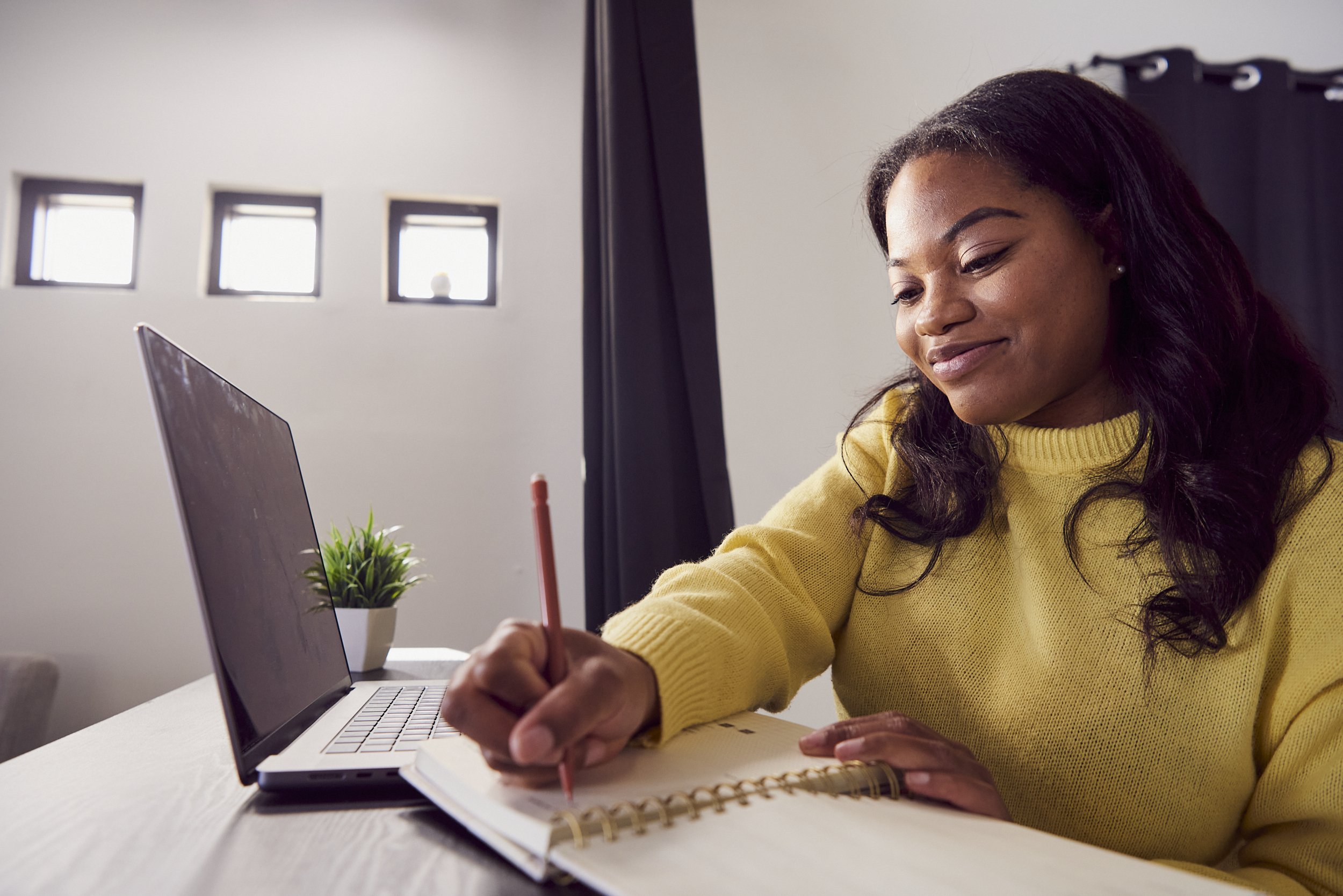 Person at a desk writing in a notebook