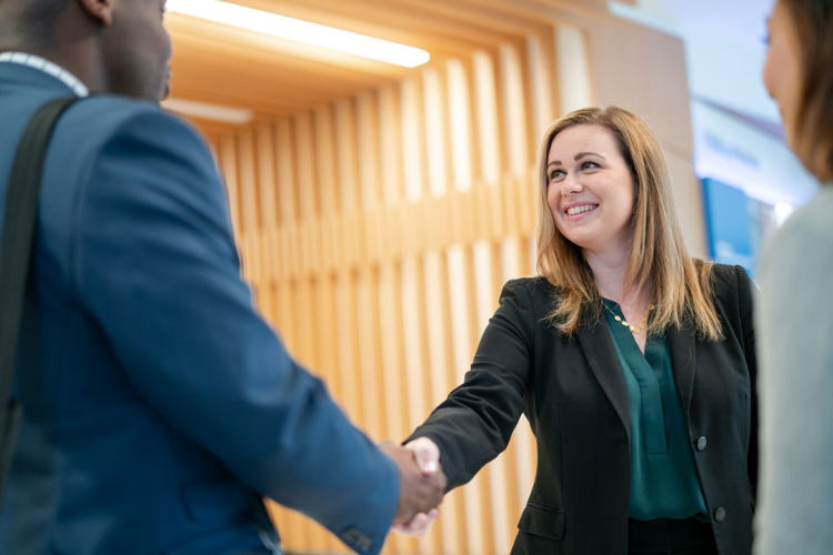 person shaking hand with another person, smiling