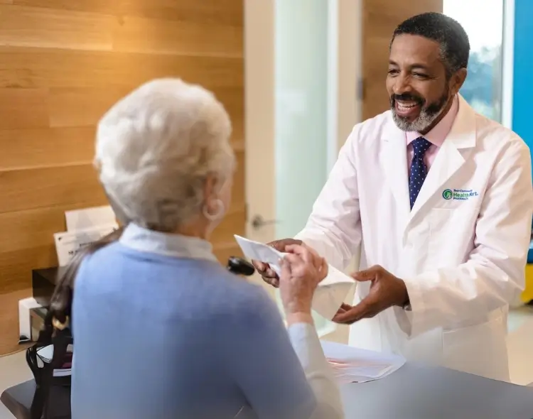 a male doctor giving prescription to a old female patient