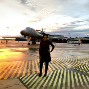 Woman standing in front of a military aircraft.