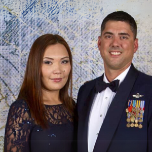 Man in uniform and woman smiling for the camera.