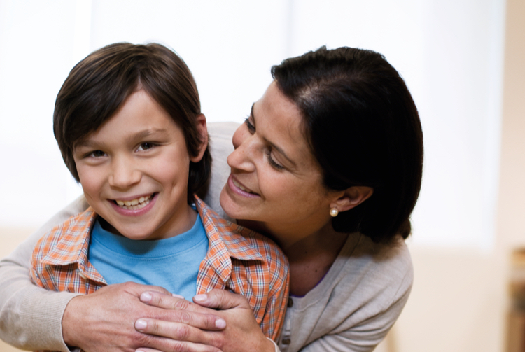 Mother and son hugging and smiling