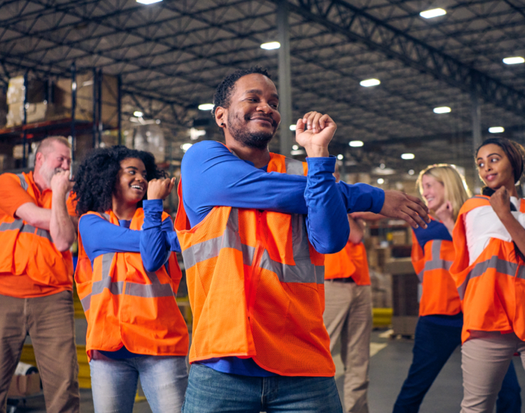 Group of workers doing yoga in warehouse
