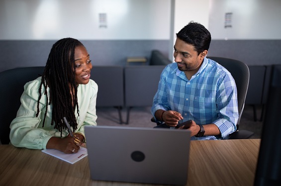 Two people working at a laptop