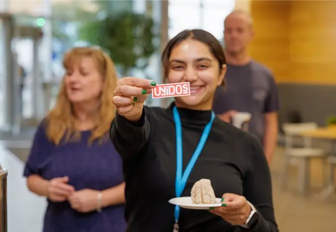 Woman holding a unidos card in front of her