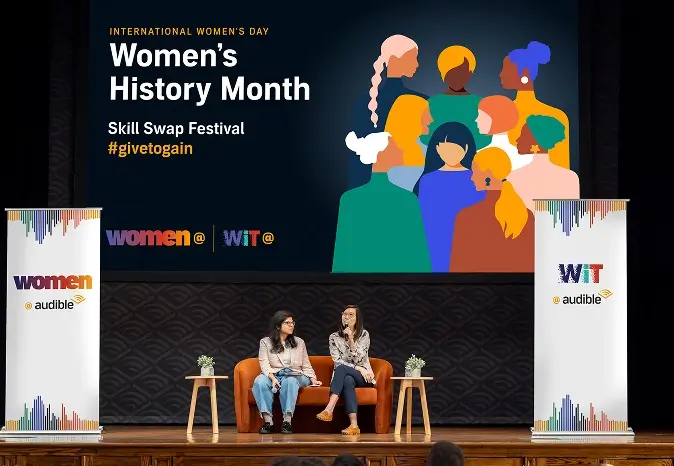 Two women on stage talking to the audience