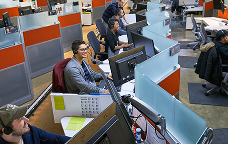 A photo of row of people working at cubicles
