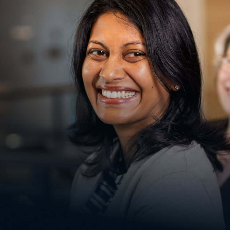 Female colleagues smiling next to each other