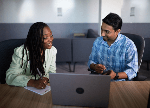 Two people working at a laptop