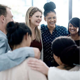Group of employees gather around a laptop