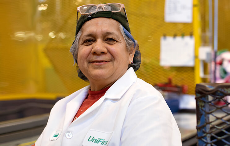 A woman in a Unifirst uniform is smiling