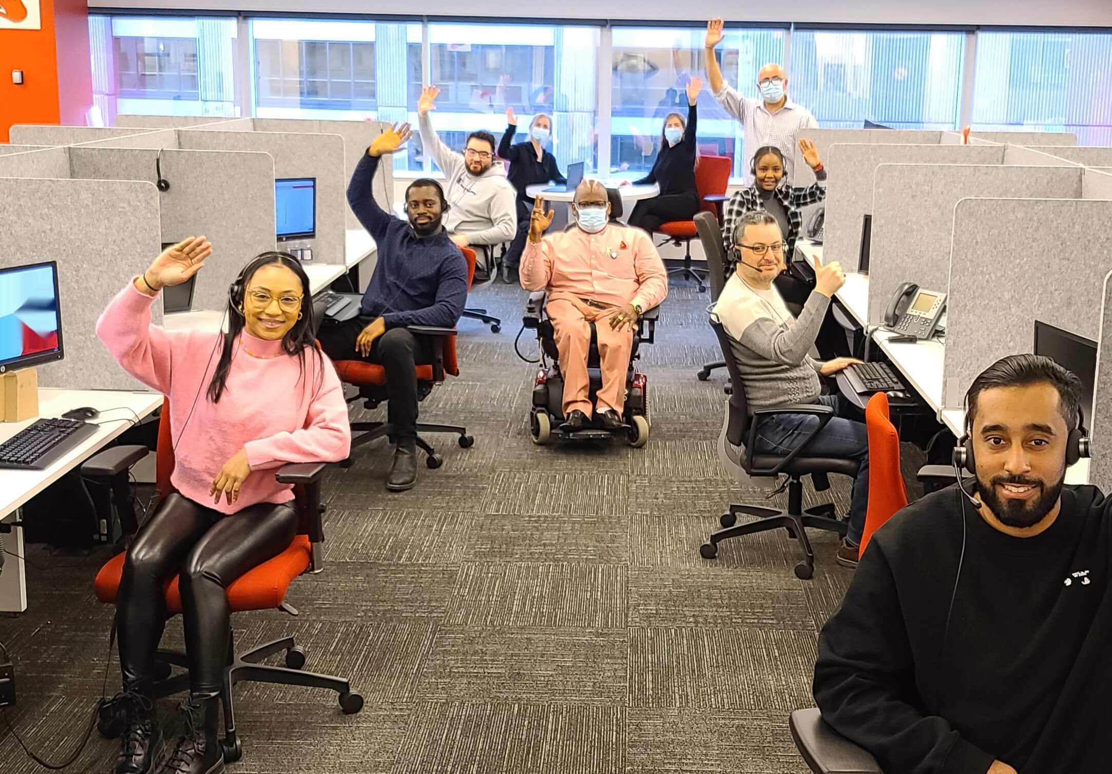 Call center office group smiling and waving