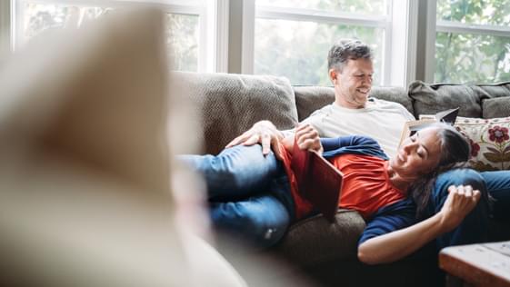 Two people relaxing on a couch at home