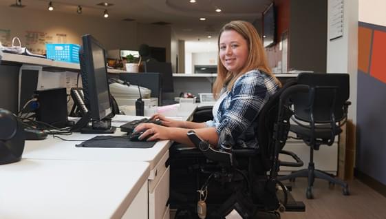 National Grid employee sitting at her desk in a wheelchair