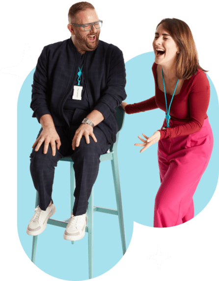 a male sitting on a stall and a female laughing