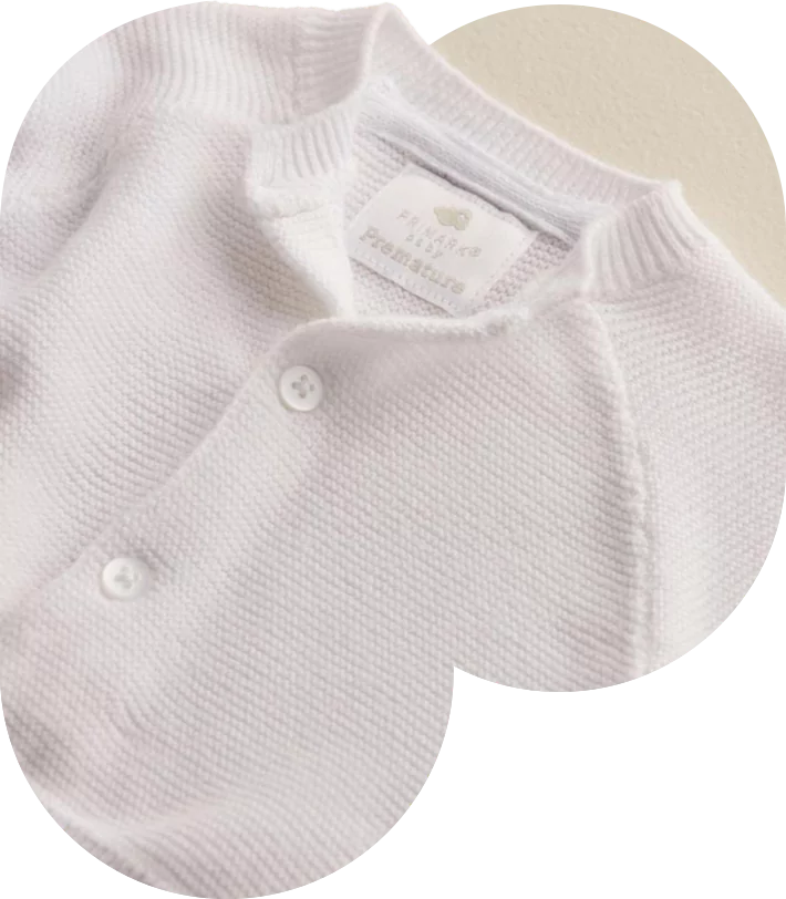 White baby sweater with front buttons.