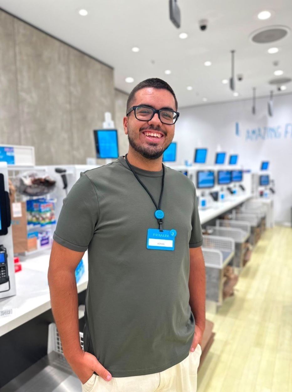 Male colleagues standing in a Primark store near the tills with hands in pockets