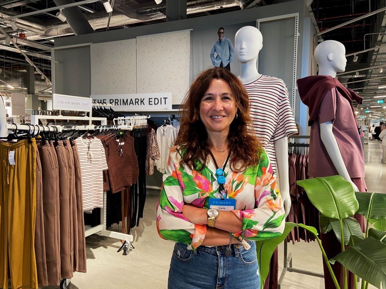 Female colleague standing in a Primark store with arms crossed