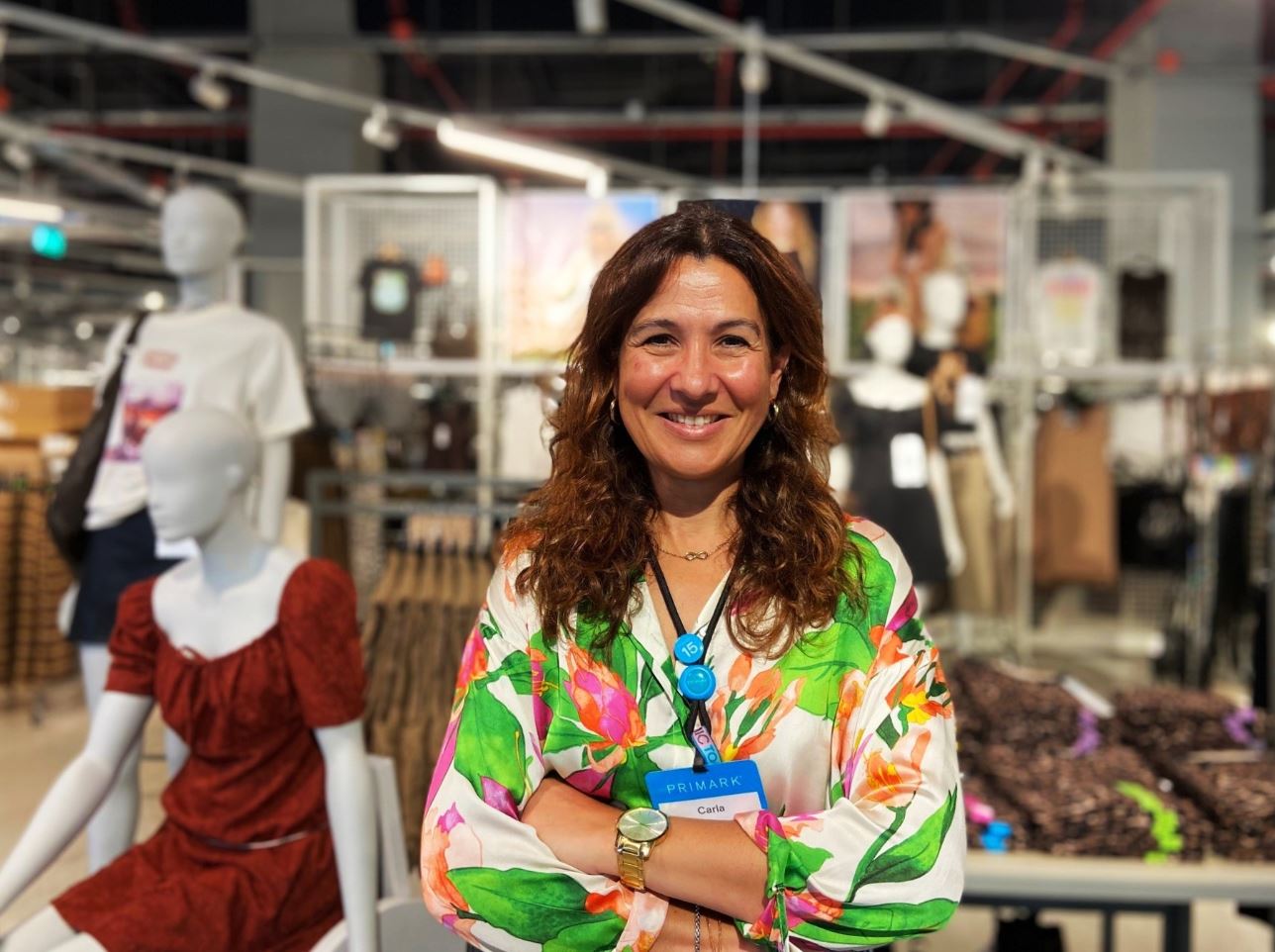 Female colleague standing in a Primark store with arms crossed
