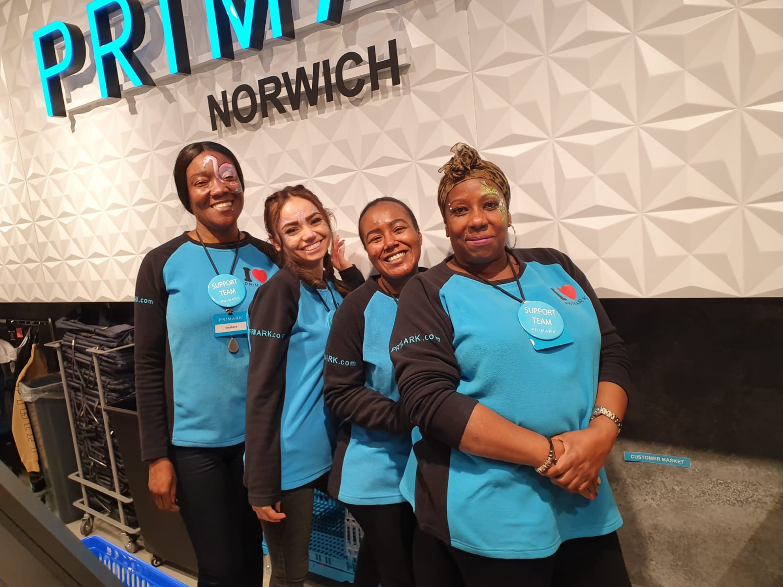 Colleagues standing together and smiling in a Primark store