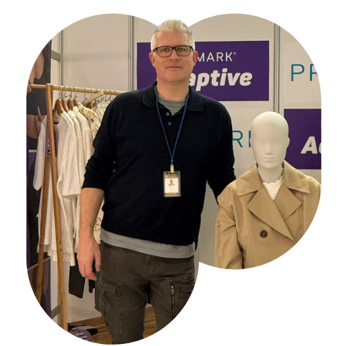 Male colleague standing beside a mannequin at a Primark Adaptive stand at a convention