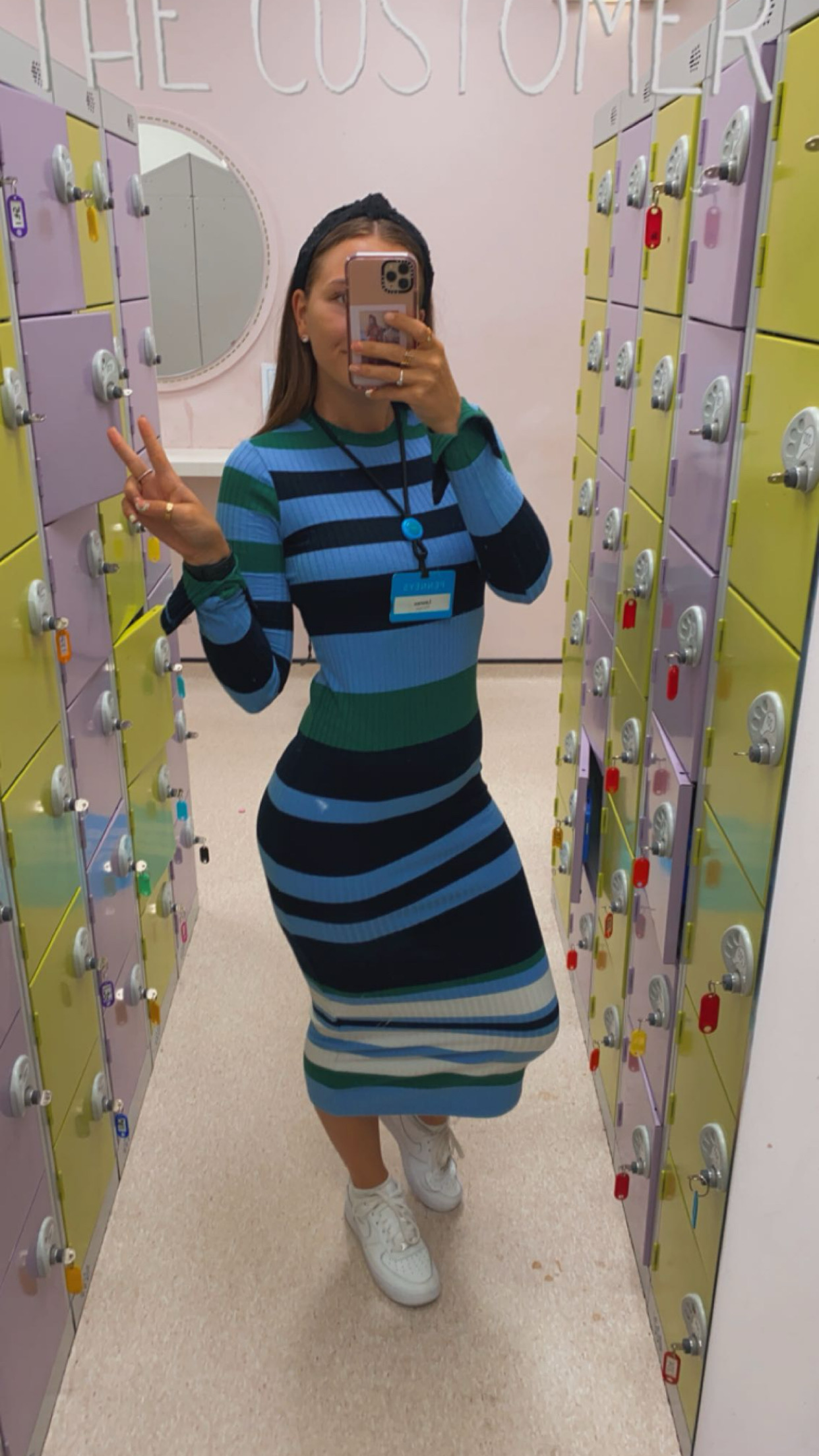 Female colleague posing and taking a picture in a mirror in colleague locker room in a Primark store