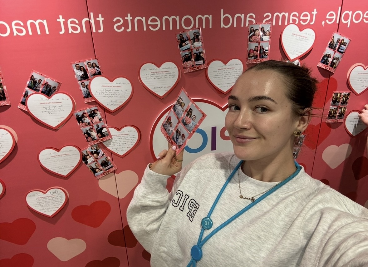 Female colleague smiling holding a phot booth photo featuring colleagues in a Primark office