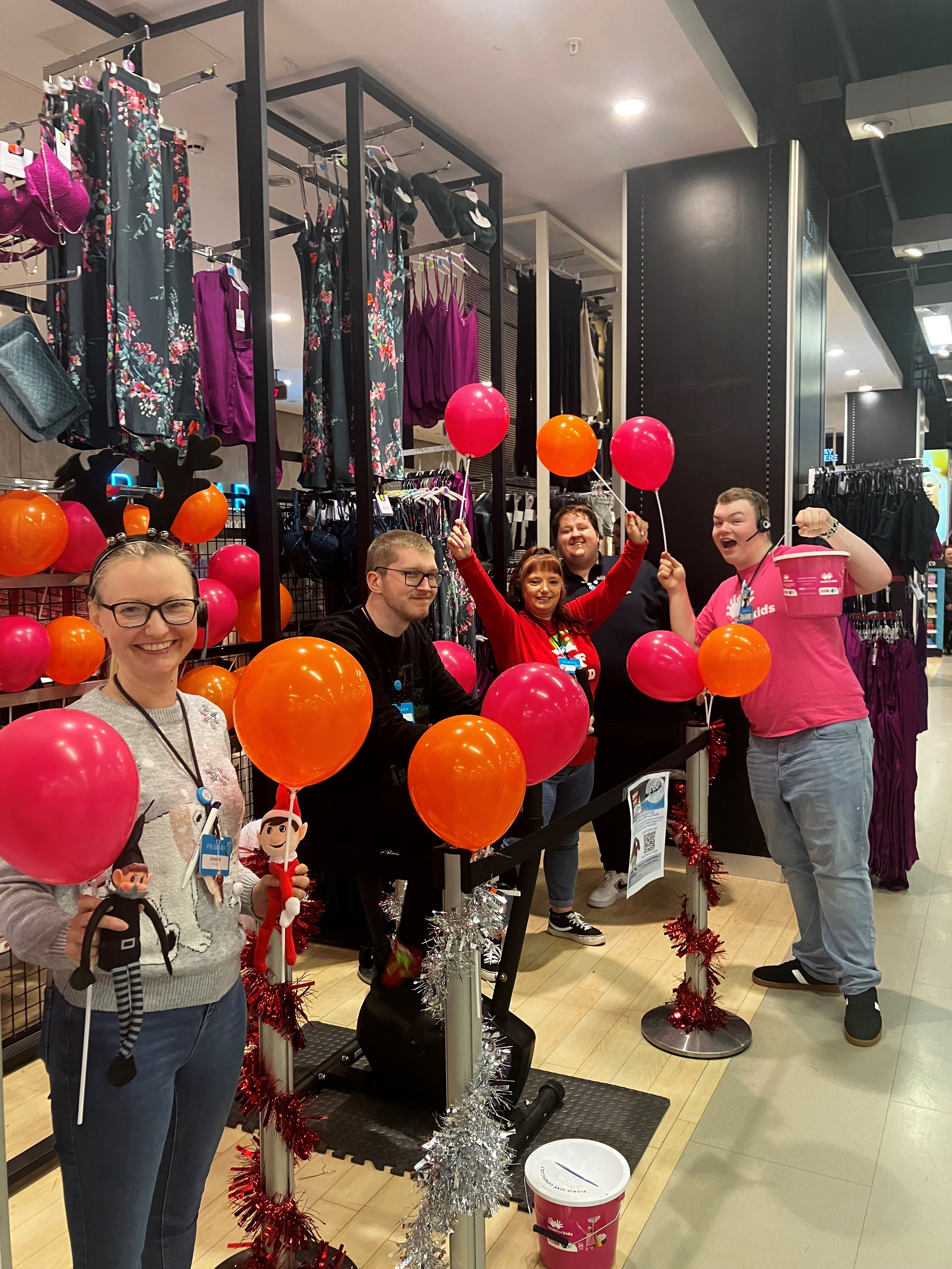 Colleagues standing together raising money for charity