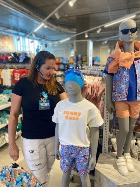 Colleague dressing mannequin in store