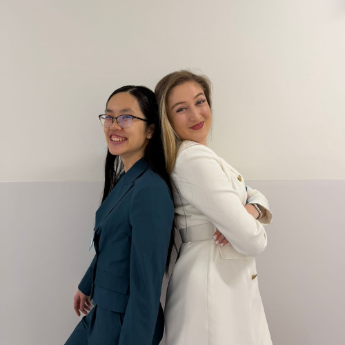 Colleagues standing back to back smiling