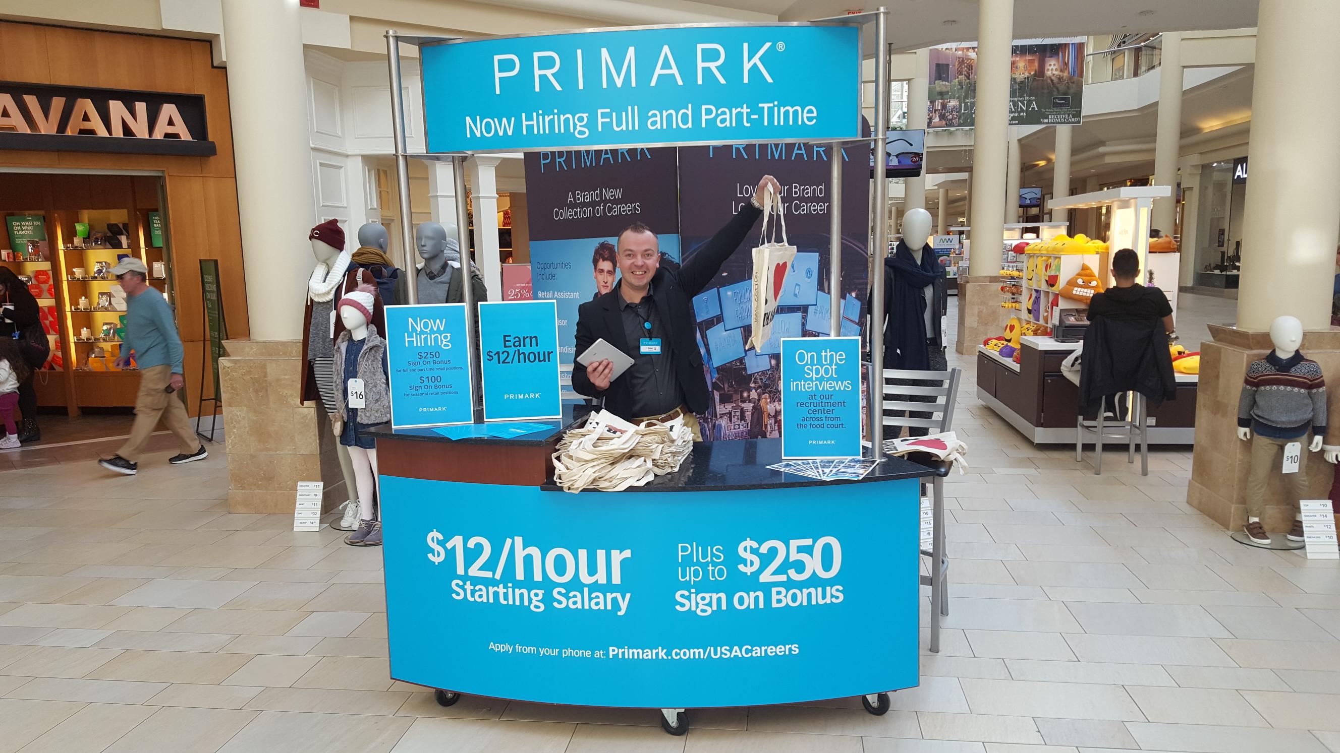 Colleague smiling and waving in stand