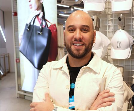 Male colleague smiling with arms crossed in a Primark store