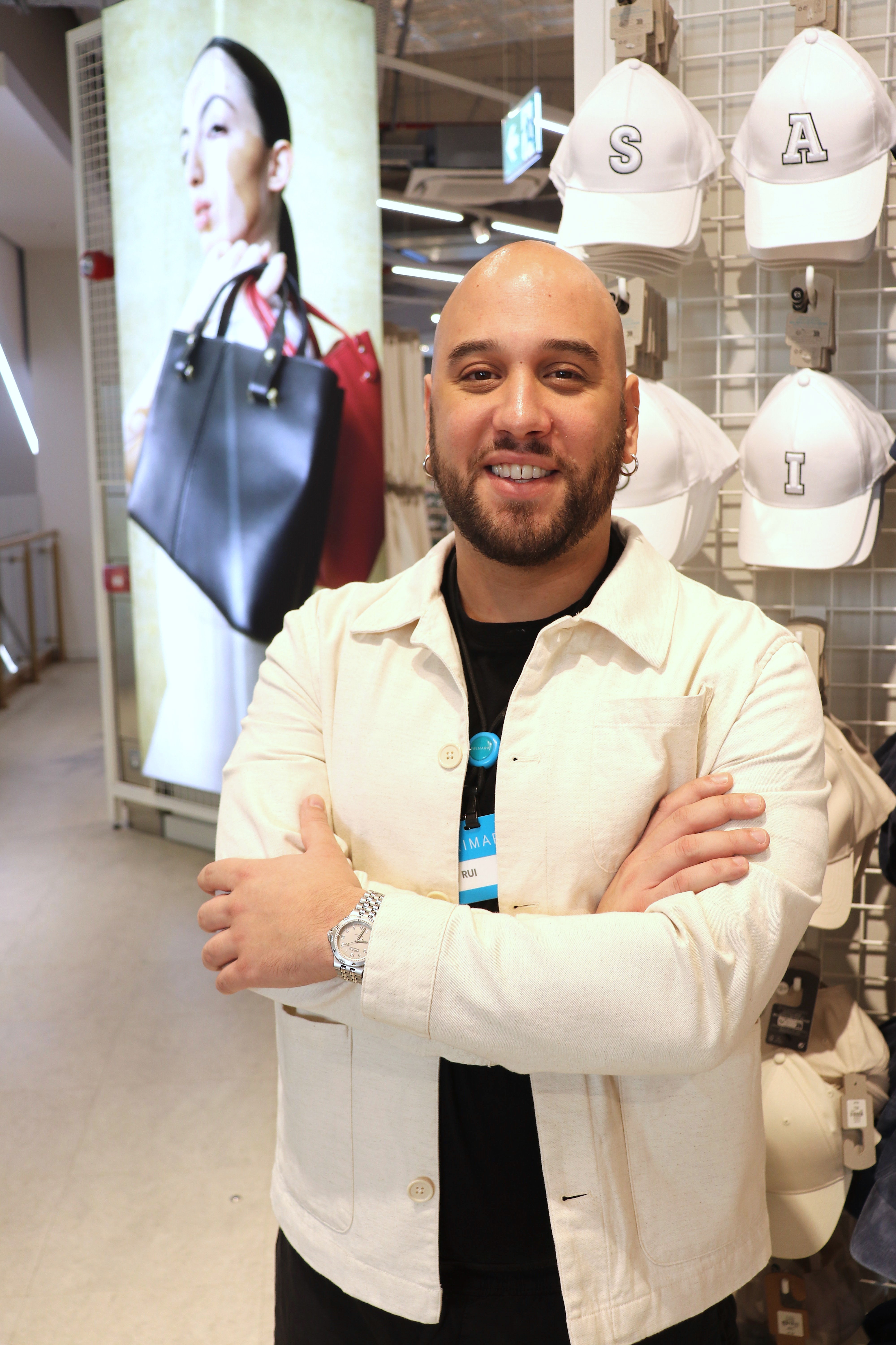 Male colleague smiling with arms crossed in a Primark store