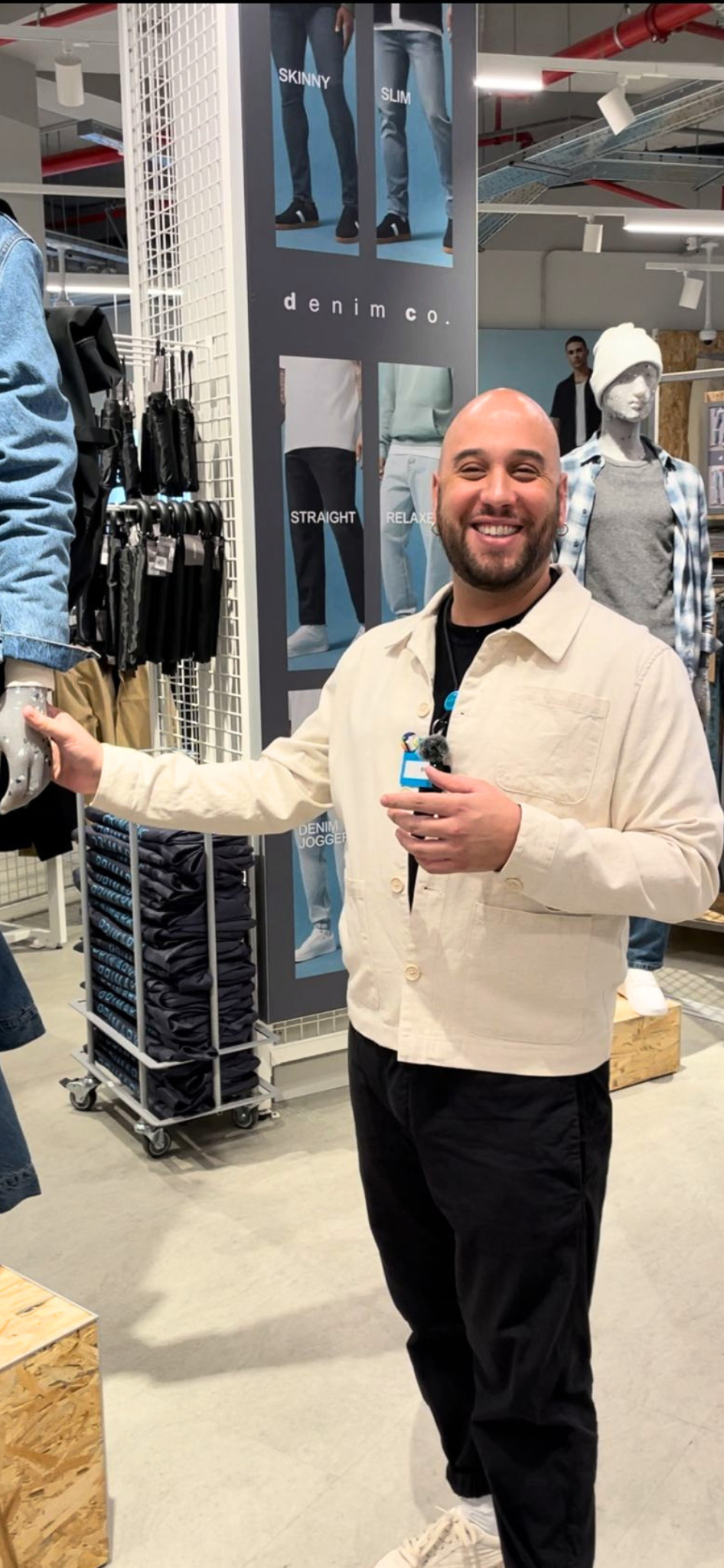 Male colleague touching mannequin with one hand in a Primark store