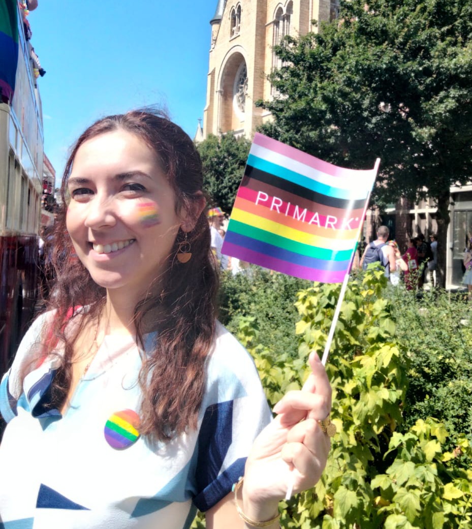 Colleague smiling and holding pride flag