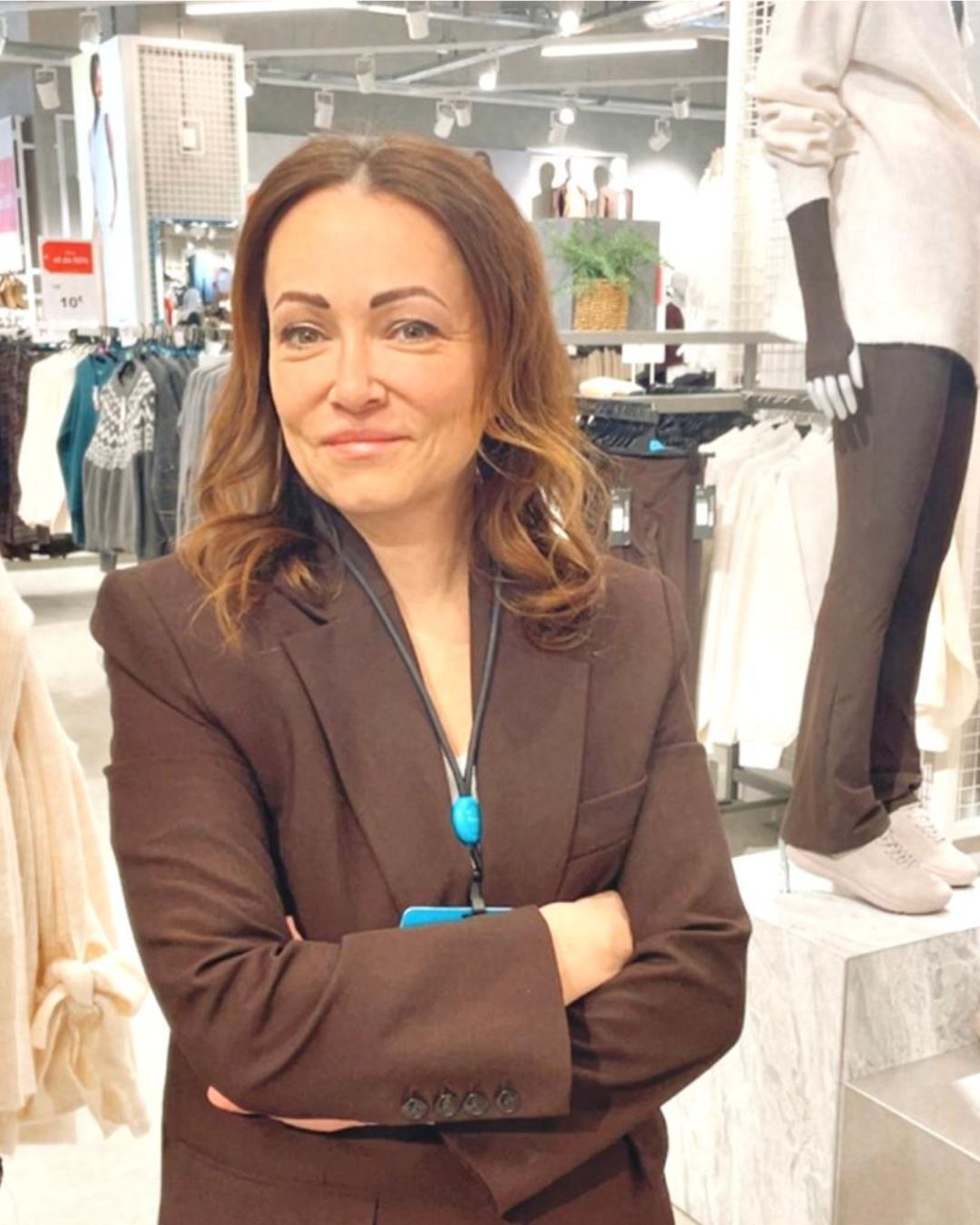 Colleague smiling with arms crossed in store