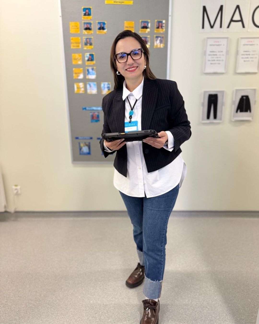 Colleague smiling holding a portable tablet device in office space