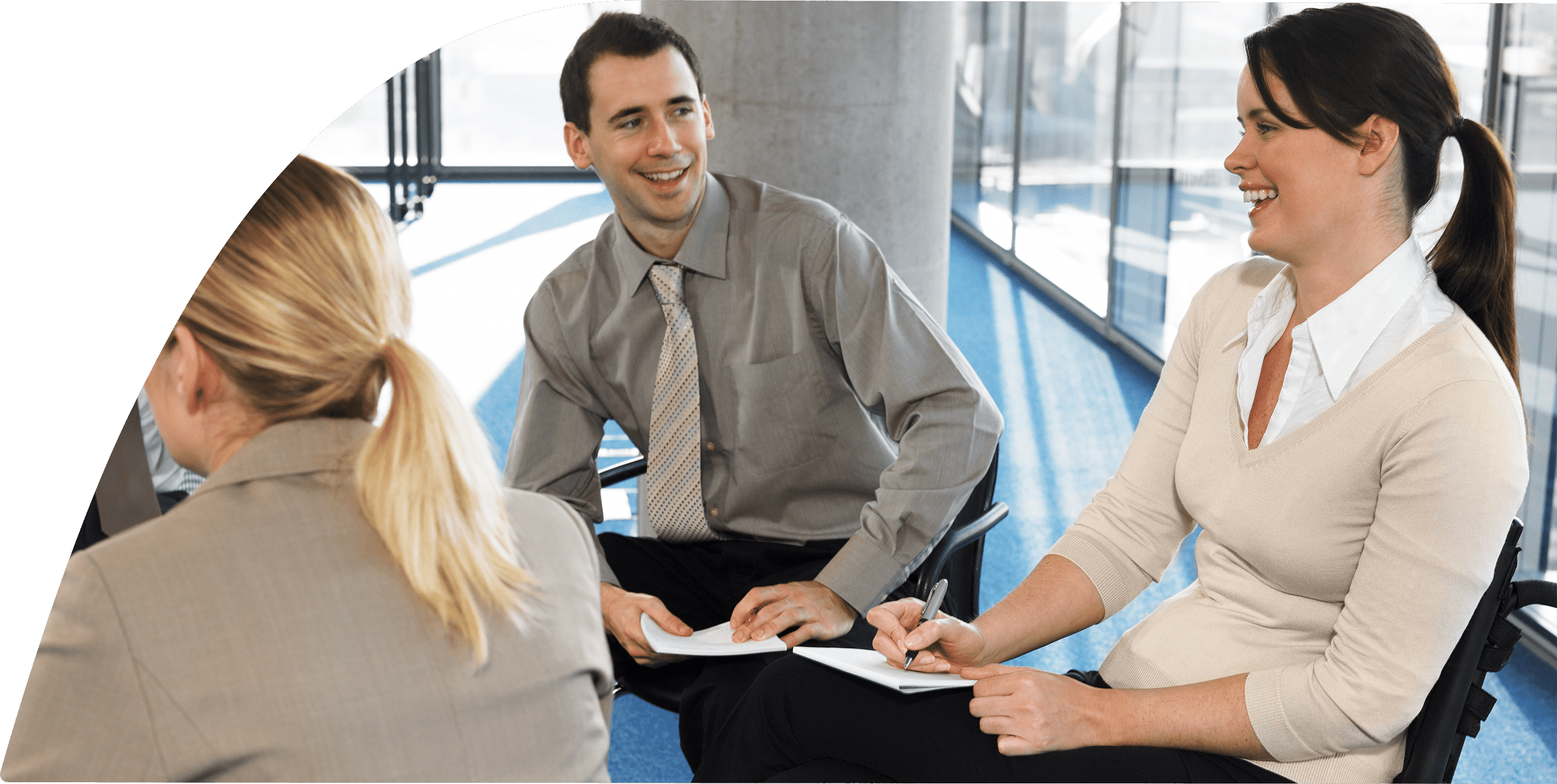 Men and women in business attire are sitting together and smiling